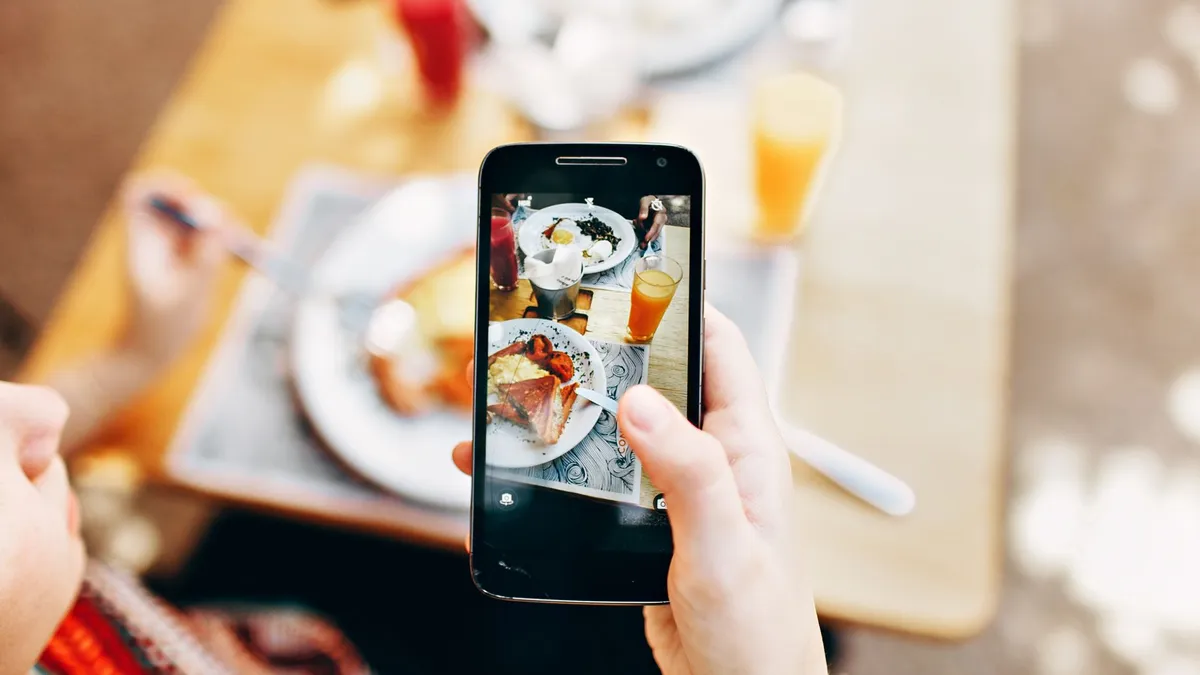 Overhead view of someone photographing a colourful meal with their smartphone to log it
