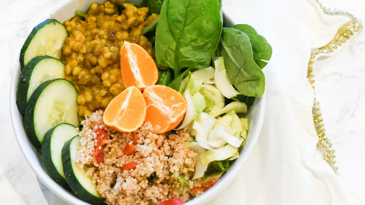 A bowl of lentil and vegetable salad with leafy greens