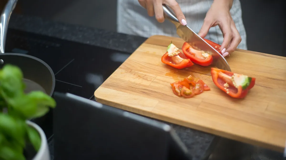 A balanced plate of grilled chicken, vegetables and grains on a wooden kitchen table