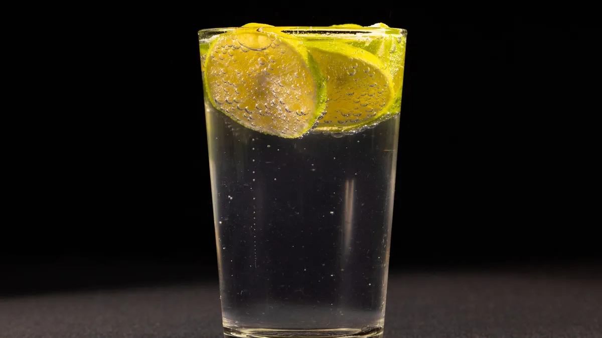 A glass of sparkling water with a slice of lime