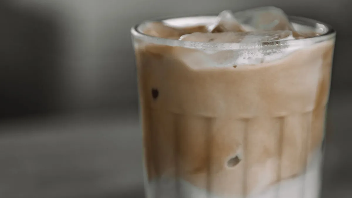 Two tall glasses of iced coffee with cream on a cafe table