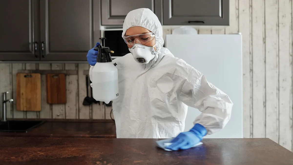 A person doing the washing up by hand at a kitchen sink