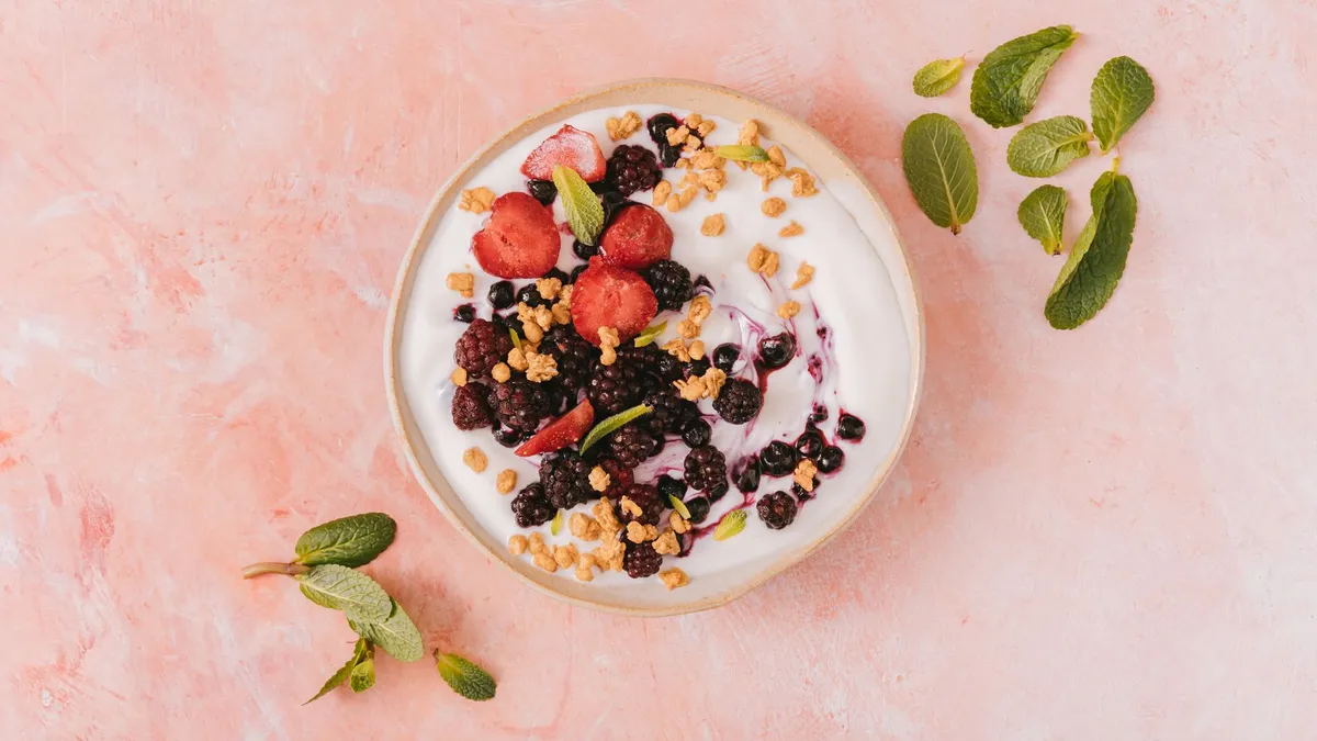 A bowl of Greek yoghurt topped with fresh berries and seeds for a high-protein breakfast