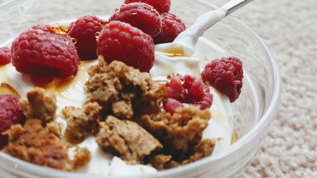 A bowl of Greek yoghurt topped with berries and seeds as a protein-rich snack