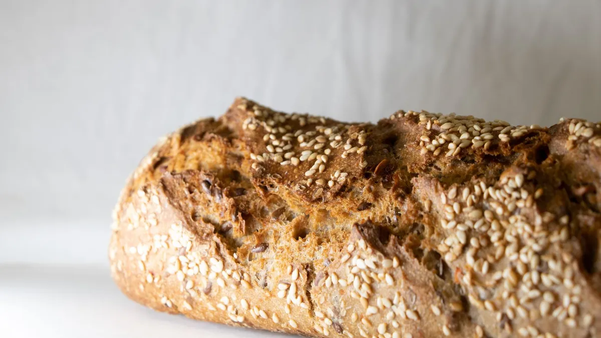 Sliced wholemeal seeded bread on a wooden board