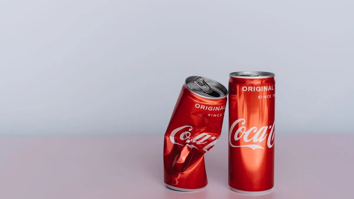 Cans of fizzy drink and sugary snacks laid out on a table