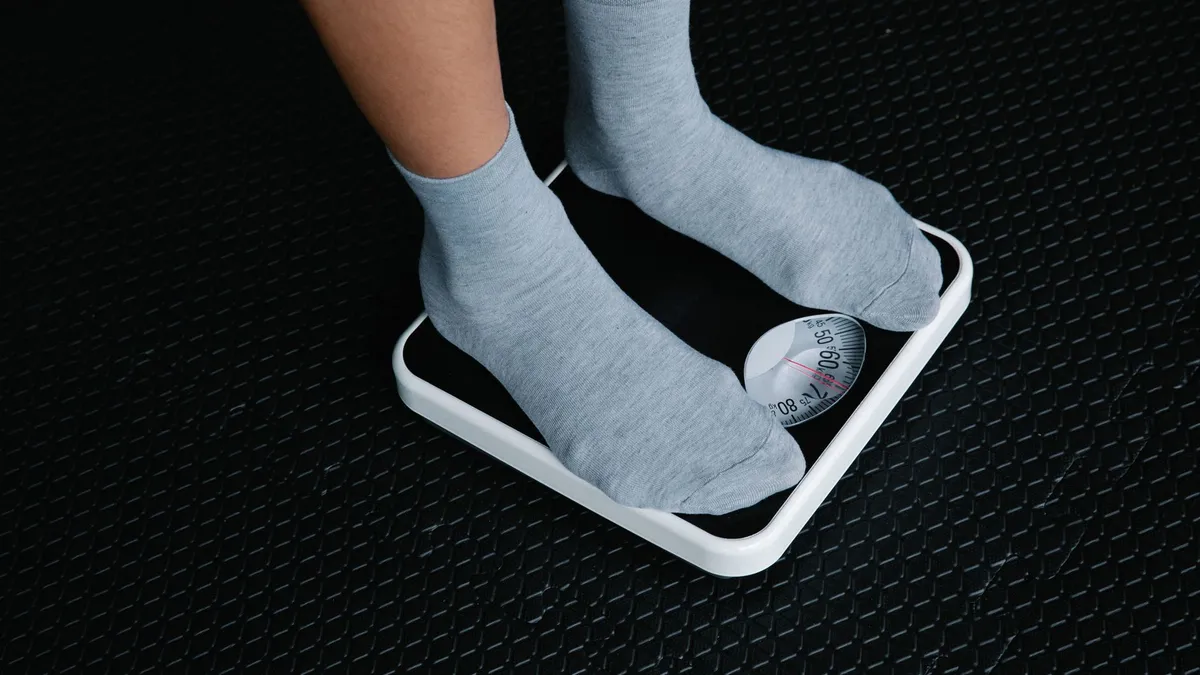 A person stepping onto a bathroom scale to check their weight